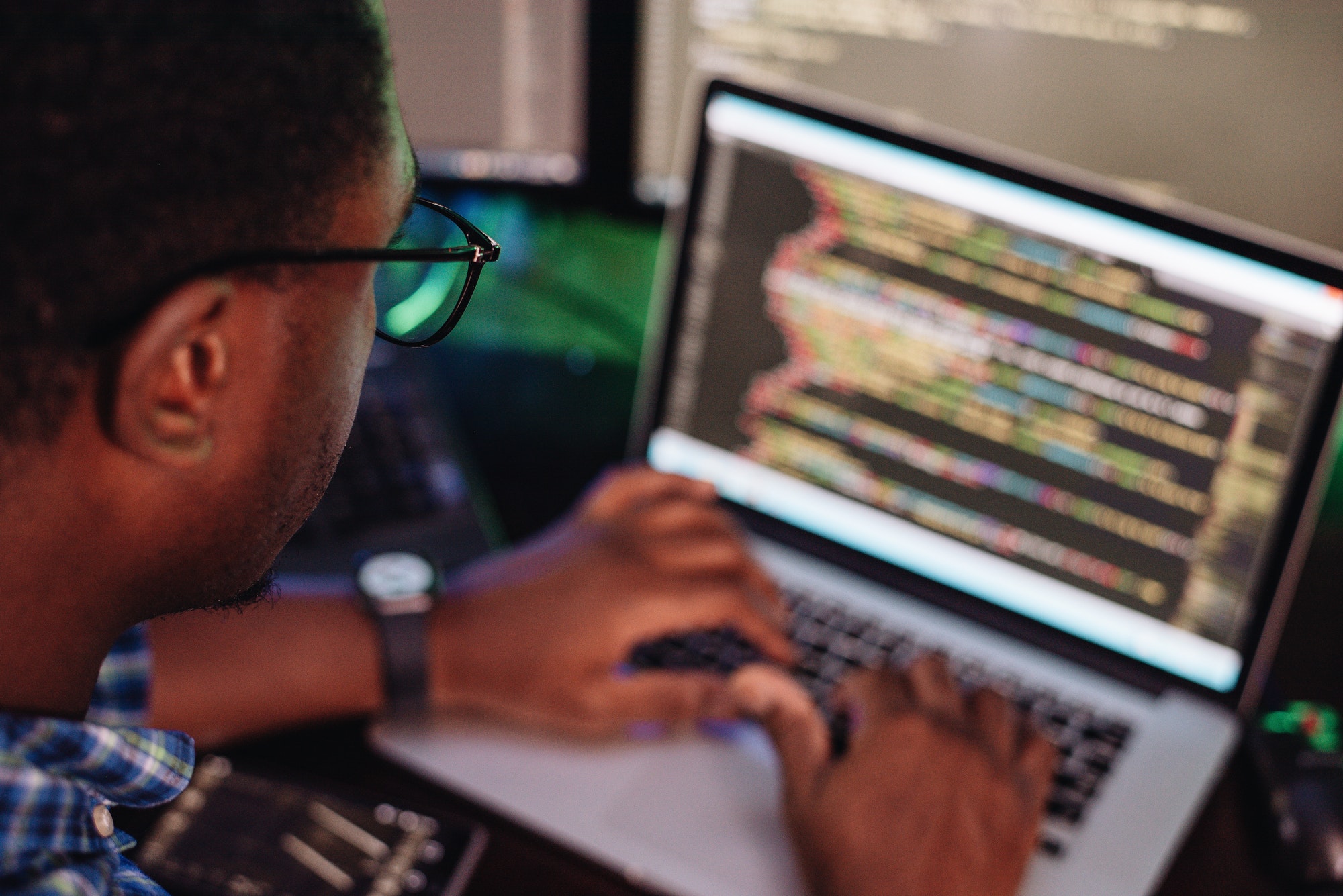black male in front of computer screen coding mobile app web development computer programming